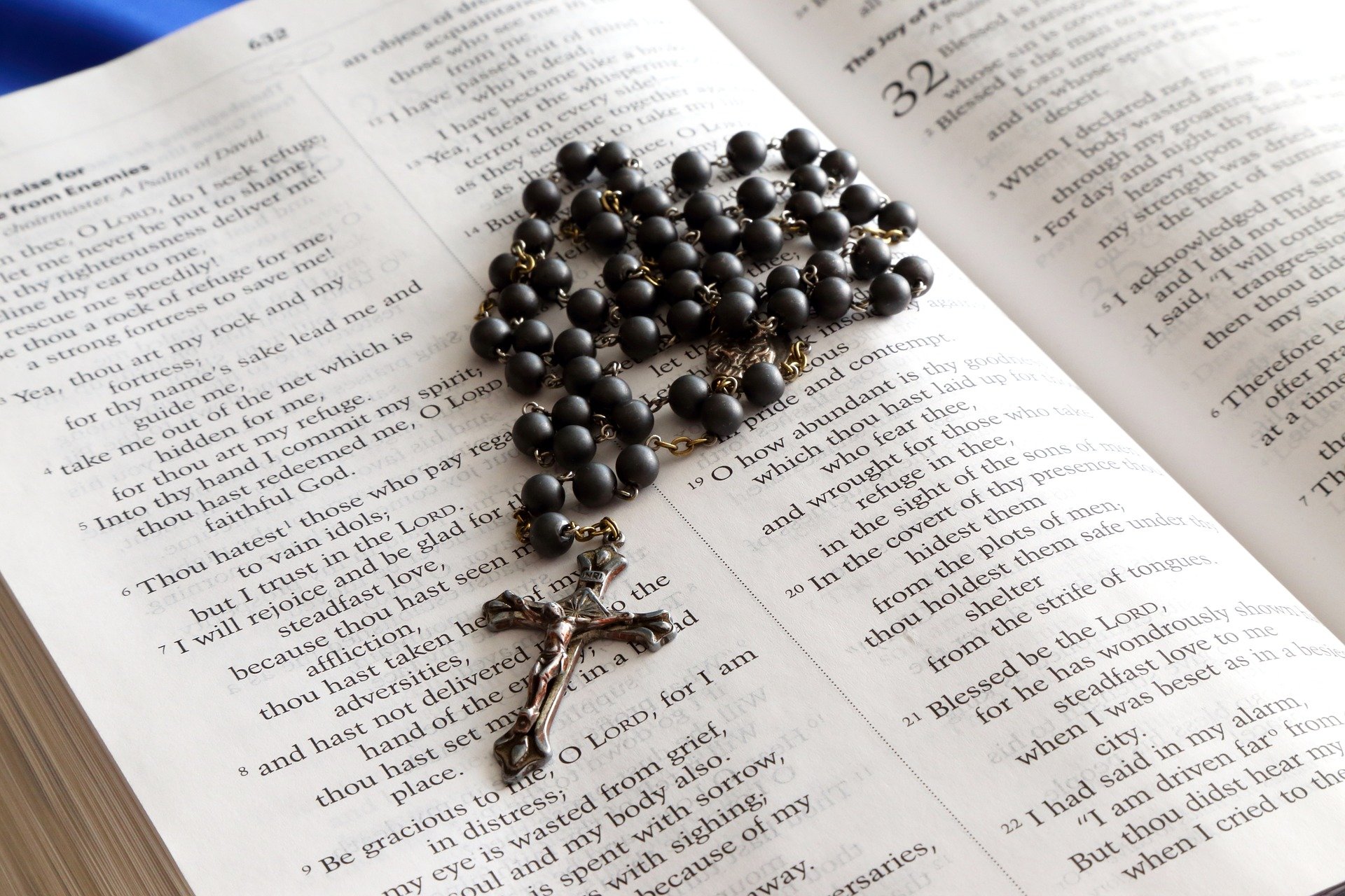 Rosary placed on top of an open bible